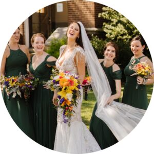 laughing bride with bridesmaids in green dresses